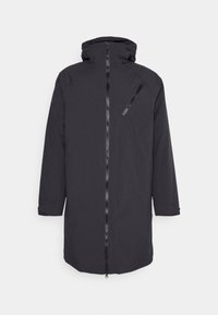 Svart lång kappa med huood, med en dragkedja fram, vinklad bröstficka och vikbara ärmslut. Tillverkad av ett slätt, matt material.