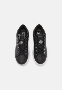Sneaker nere in pelle con punta liscia, pannelli laterali testurizzati, suola in gomma bianca e accento in argento sul laccio.