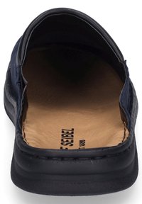 Námořnické kožené mokasíny s hladkým povrchem a polstrovanou béžovou stélkou. Otevřená zadní část s viditelným švem na okrajích.