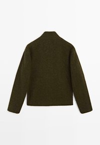Tmavě zelený vlněný kabát s texturovaným povrchem, má vysoký límec a rovný střih, dlouhé rukávy a minimální designové detaily.