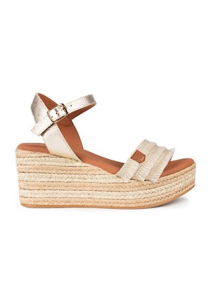 Sandalia de cuña con una correa de tobillo en metal dorado, plataforma de yute trenzado, parte superior de tela beige con un diseño fruncido y plantilla acolchada marrón.