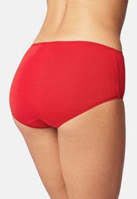 Czerwony dół bikini wykonany z gładkiego, elastycznego materiału. Charakteryzuje się niskim stanem, minimalnym zakryciem i starannie przeszytymi brzegami.