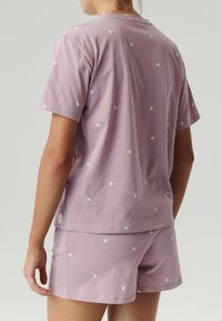 Jasnofioletowy strój do spania z bawełny, składający się z bluzki z krótkim rękawem i pasujących szortów, ozdobionych białym wzorem nasion dmuchawca.