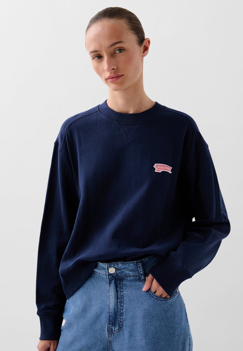 Marineblauwe longsleeve sweatshirt van katoen, met een geribbelde ronde hals en een rood geborduurd logo-opdruk op de borst. Casual pasvorm.