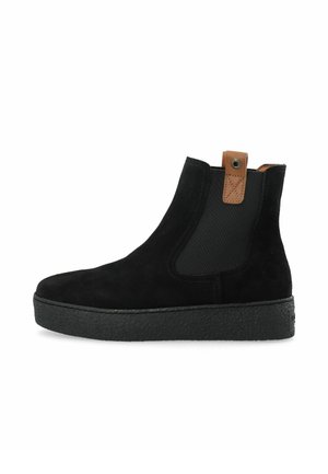 Bottine en daim noir avec semelle épaisse texturée, panneau latéral élastique et languette en cuir marron avec œillet métallique.