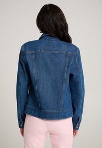 Tamsiai mėlynas džinsinis švarkas su klasikinio stiliaus apykakle, ilgomis rankovėmis ir sagų detalėmis. Lygus audinys su vertikaliomis siūlėmis.