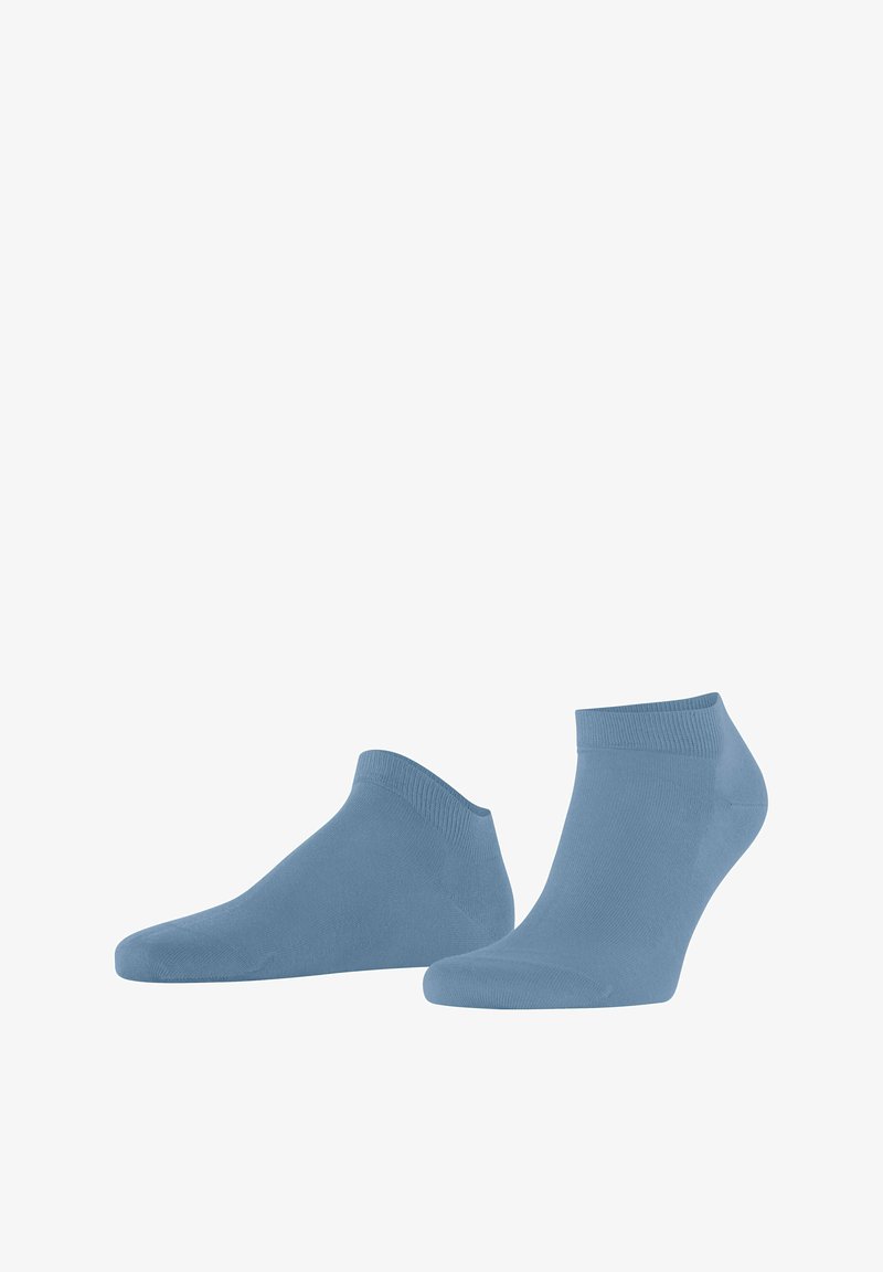 Paire de chaussettes bleu clair à la cheville, présentées sur un fond blanc, une chaussette debout et l'autre posée sur le côté.