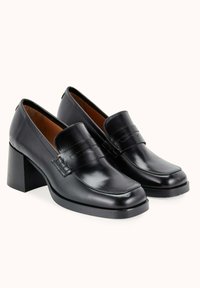 Mocassins à talons en cuir noir avec une finition lisse, un bout carré, des détails de couture subtils et un talon block chunky.