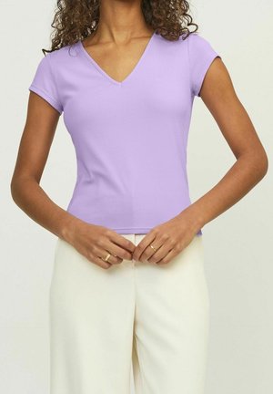 Lawendowa top na prążkowanym materiale z dekoltem w serek i krótkimi rękawami, zestawiona z kremowymi spodniami o szerokich nogawkach. Materiał wydaje się miękki, o dopasowanym kroju.