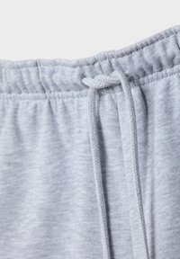 Lichtgrijze joggingsbroek met een elastische tailleband, verstelbaar trekkoord en zachte, gestructureerde stof.