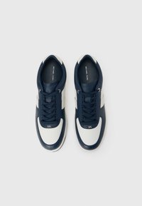 Αθλητικά παπούτσια από δέρμα σε ναυτικό μπλε με λευκές λεπτομέρειες, σχέδιο με κορδόνια, στρογγυλεμένη μύτη, υφασμένα πάνελ και λεπτομέρεια λογότυπου στο πλάι.