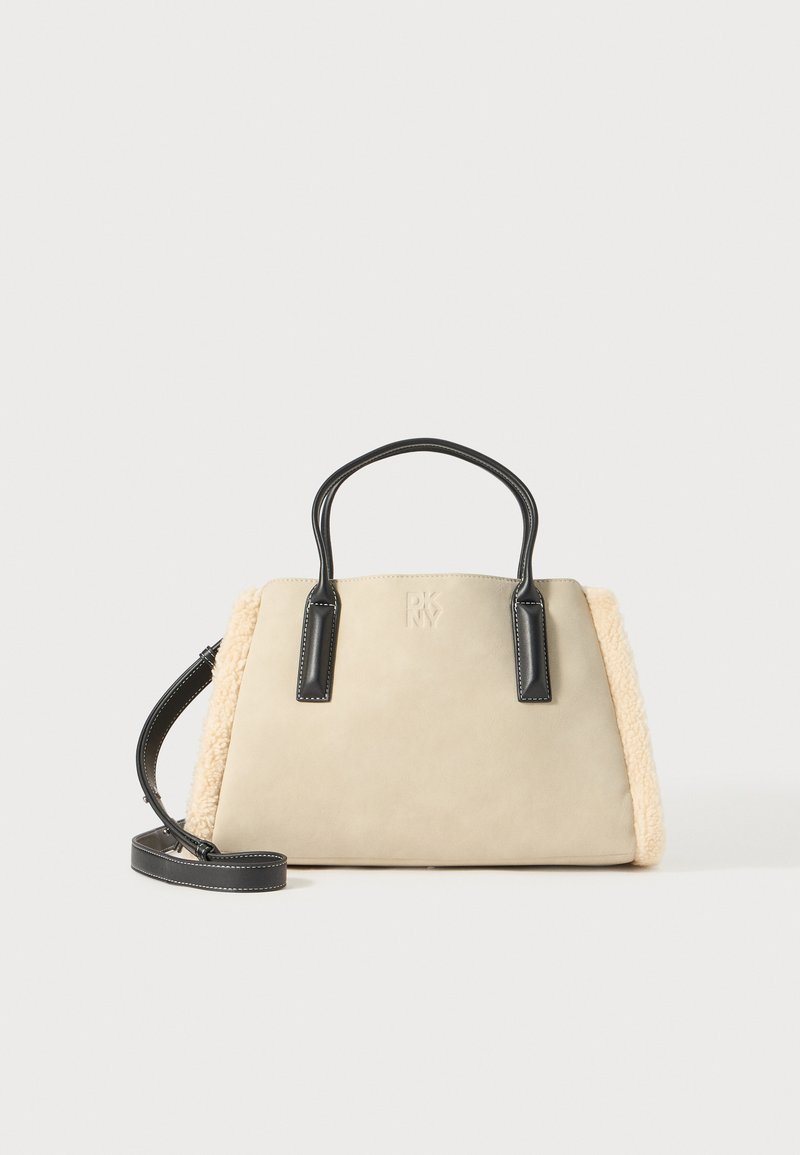 Beige kunstlæder håndtaske med sorte læderdetaljer, dobbelte håndtag og en tekstureret cremet shearling-side. Justerbar skulderrem inkluderet.