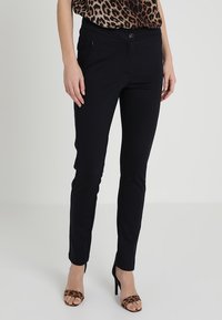 Black stretch pants made of soft fabric, featuring a slim fit, a button closure, and side pockets, worn with leopard print heels.