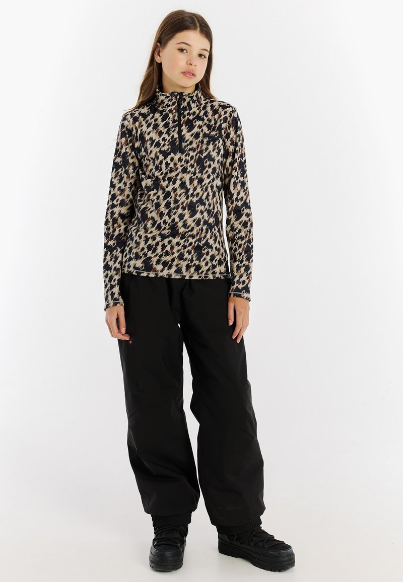 Dlhý rukáv, vysoký golier s leopardím vzorom v hnedých a čiernych farbách; skombinované s voľnými čiernymi nohavicami a čiernymi čižmami.