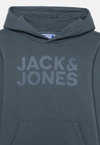 Hoodie gris foncé avec un grand logo ton sur ton "JACK & JONES" sur le devant, fabriqué en tissu doux et texturé, doté d'une poche kangourou.