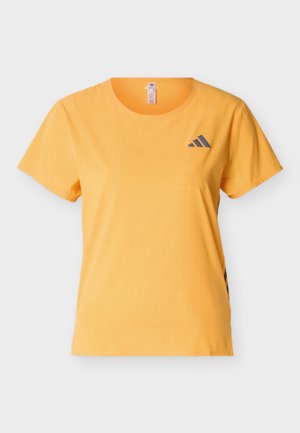 Żółty sportowy T-shirt z krótkim rękawem, z drobnymi perforacjami, okrągłym dekoltem i czarnym logo Adidas na górnej lewej stronie klatki piersiowej.