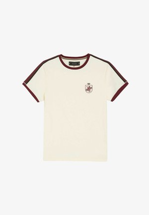 Biała bawełniana koszulka z bordowym żeberkowanym dekoltem i brzegami rękawów. Posiada mały emblemat lwa z koroną na piersi.