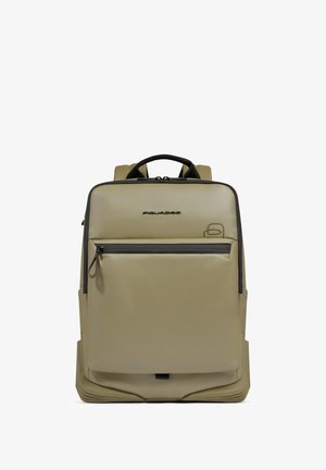 Beige rechthoekige rugzak met zwarte ritssluiting op het voorvak, zwart handvat en subtiel merkembleem nabij het midden bovenaan, tegen een witte achtergrond.