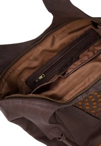 Brown leather handbag with a zippered pocket and soft lining. Features woven accents and a large, open compartment for storage.