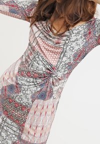 Bunt gefärbtes Kleid mit filigranen Mustern in Rot, Blau und Schwarz, mit einem gerafften Design und glattem, leichtem Stoff.