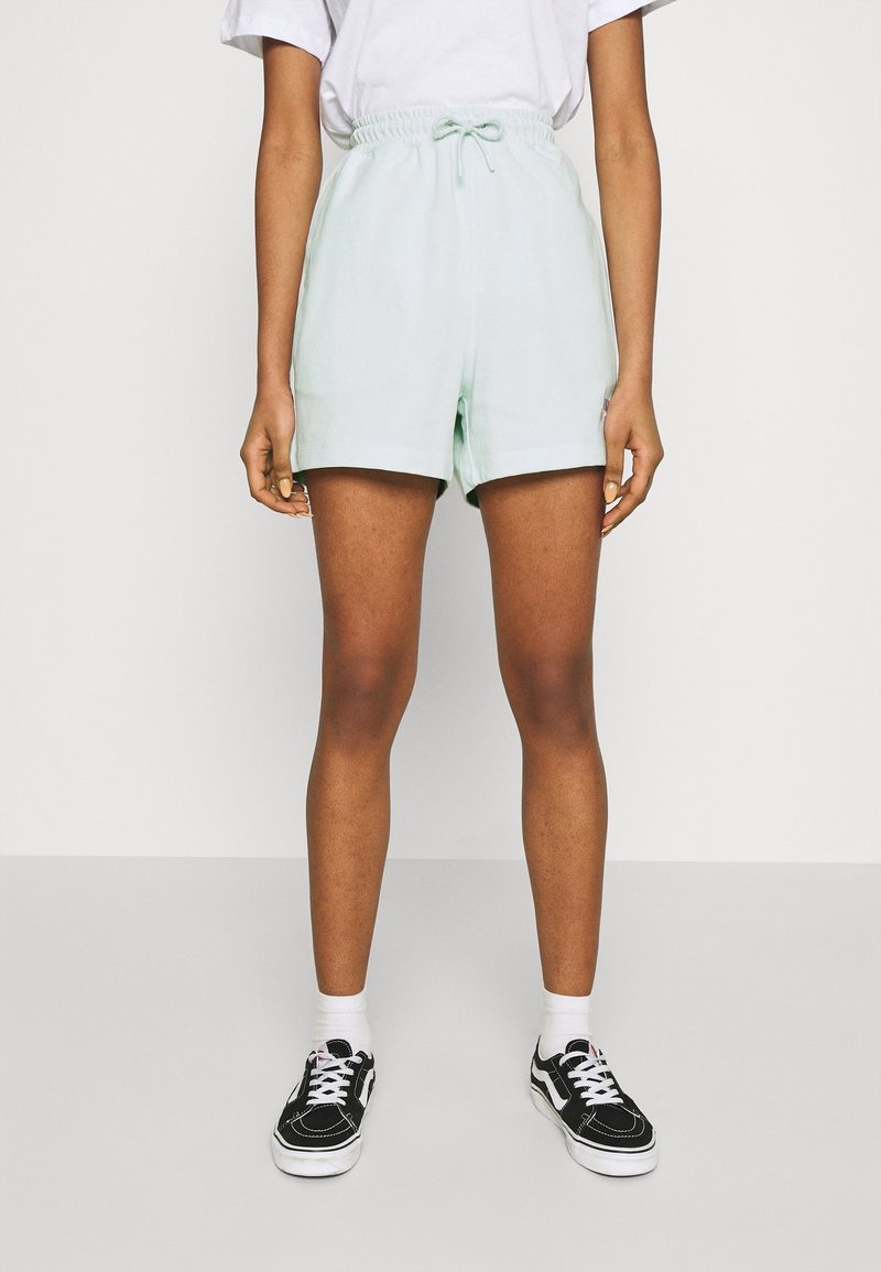 Svetle mátové kraťasy vyrobené z měkké tkaniny, s elastickým pasem a šňůrkou. Rovný střih s bočními kapsami.