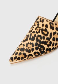 Chaussure à talon aigu en imprimé léopard avec une surface lisse et texturée et des accents noirs, présentant une silhouette élégante et une variation de couleur naturelle.