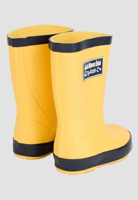 Bottes de pluie en caoutchouc jaunes avec une surface texturée, semelle noire et bord supérieur. Comprend un patch logo sur le côté.