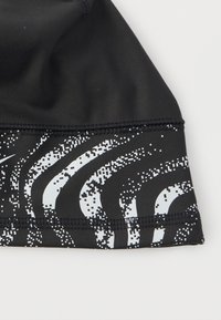 Μαύρο σκουφάκι κολύμβησης με λευκό ψηφιακό κυματιστό σχέδιο και ραφές. Κατασκευασμένο από λεία, ελαστική ύλη σχεδιασμένη για εφαρμογή που αγκαλιάζει το κεφάλι.