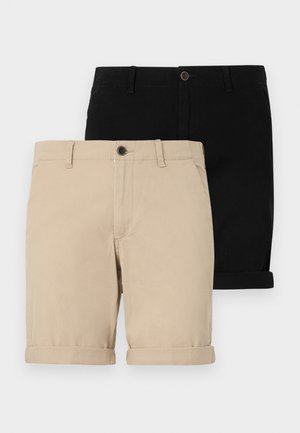 Twee paren opgerolde shorts: een beige en een zwarte, gemaakt van gladde stof, met een frontknop en een klassiek ontwerp.