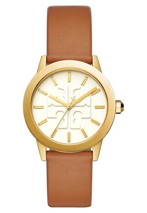 Montre ronde en or avec un cadran blanc, des marqueurs d'heure dorés et des aiguilles, et un bracelet en cuir marron affichant un motif croix sur le cadran.