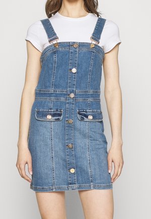 Denim overall dress in light blue, featuring adjustable straps, front button closure, two front pockets, and a fitted design.