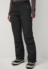 Black waterproof snow pants with two zippered pockets and a waistband featuring two buttons and adjustable Velcro for a secure fit.