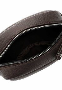 Borsa in pelle marrone con una finitura testurizzata. Presenta una cerniera argentata e un'apertura superiore, che rivela un rivestimento interno nero. Forma compatta e rotonda.