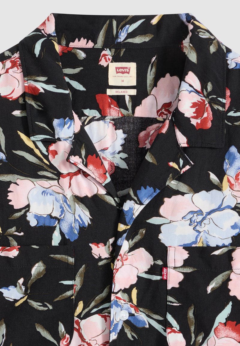 Sort Levi’s afslappet skjorte med stort pink, rødt, blåt og hvidt blomsterprint, spredekrave samt synlig frontlomme og knapper.