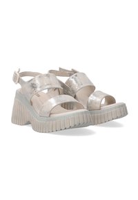 Wedge sandalen met een metallic zilveren afwerking, brede kruislings straps, open teen, en een gestructureerde lichtgrijze rubberen zool met verticale groeven.