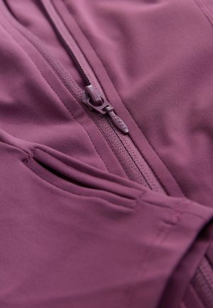 Paarse sportjas met een centrale rits, een gladde textuur en zijzakken met een gestroomlijnd ontwerp.
