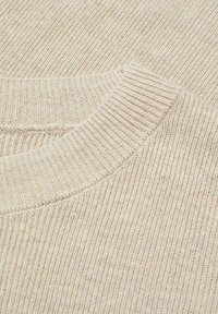 Pull en maille de couleur crème avec une texture côtelée et un col rond. Vue en gros plan mettant en valeur le tissu doux et le motif uniforme.