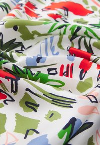 Colorful, lightweight fabric with abstract patterns in red, green, blue, and black on a white background. Smooth texture, slightly glossy finish.