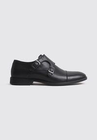 Zapatos de vestir de cuero negro con acentos de doble hebilla, punta redondeada y tacón ligeramente elevado. Textura lisa con un diseño elegante.