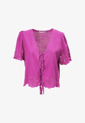 Kurzärmelige magentafarbene Bluse mit floralen Ausschnittmustern, geschwungenen Kanten und vorne bindbaren Verschlüssen.
