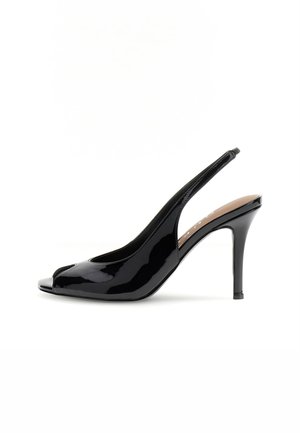 Czarny lakierowany but na obcasie typu slingback z wąskim noskiem i cienkim obcasem szpilkowym na białym tle.