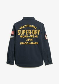 Dark navy long-sleeve shirt with yellow embroidered text and stripes on sleeves. Features a collar and buttoned cuffs.