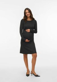 Langdurige, zwarte, getailleerde zwangerschapsjurk met een sprankelende textuur en een knielange zoom, met een ronde halslijn en rekbaar materiaal.