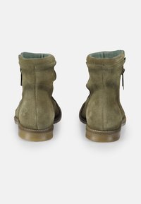 Botas de ante verde hasta el tobillo con cierre de cremallera, diseño curvado en la parte trasera y suela de goma texturizada. Forro interior suave.