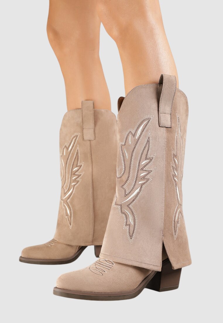 Bottes de cowboy en suède beige avec broderies décoratives en forme d'aile, bout carré et petit talon carré ; dotées d'une languette pour un enfilage facile.