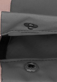 Grå tygpås med en rosa kant, som har ett knäppfäste och en texturerad yta. Inuti finns en slät, mörkgrå foder.