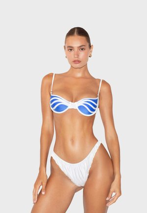 Set bikini con un top bianco decorato con motivi a onde blu, supporto con ferretto e spalline sottili; slip bikini bianco arricciato coordinato.