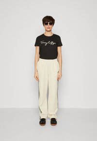 Tommy Hilfiger TAPE RELAXED - Tracksuit bottoms - calico