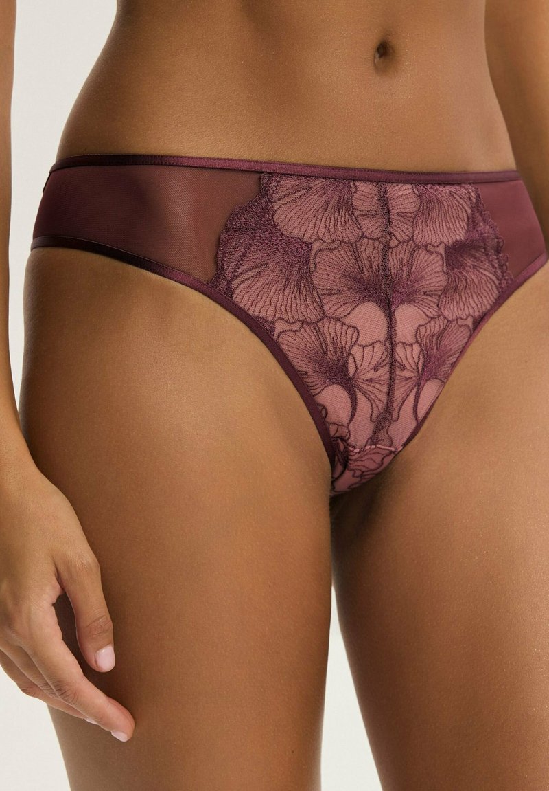Burgundowy koronkowy stringi z kwiatowymi haftami, z gładkim pasem w talii i kontrastującymi przezroczystymi panelami, podkreślającymi delikatny design.