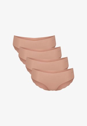 Jonge vrouw met krullend haar, gekleed in een bijpassende beige beha en ondergoed, licht glimlachend tegen een effen achtergrond.